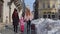 Sisters tourists travelers walking with a suitcase on snowy city street, enjoying time together