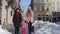 Sisters tourists travelers walking with a suitcase on snowy city street, enjoying time together