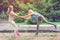 Sisters twins have fun together in a park in a summer.