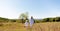 Sisters walk across the field, holding hands. Time with family. Cheerful picnic in the park