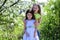 Sisters walk outside near white blooming trees. Children pose together