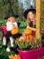 Sisters in witch costumes sitting together on wooden terrace