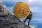 Sisyphus concept showing man struggling to push giant Bitcoin up a mountain representing goal of mining and getting rich