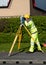 Site engineer surveying coordinates and levels of points on existing road using total station installed