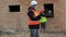 Site manager checking documentation and worker in background near boards