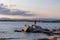 Sithonia - Woman in red dress standing on rock with panoramic view of coastline during sunset near Karydi beach, Greece