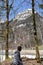 A sitting boy between conifer trees observing KlÃ¶ntalersee lake in early spring sunny day in KlÃ¶ntal