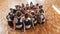 Sitting on circle. Group of female kids practicing athletic exercises together indoors
