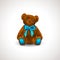 Sitting fluffy cute red brown or rufous teddy bear toy with bright blue ribbon or bow. Children`s toy isolated on white backgroun