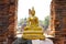 Sitting golden buddha statue in old ruined temple