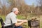 Sitting Male Elderly Preparing Food to Eat Outside