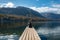 Sitting on a small jetty and enjoying the view on the landscape of lake Bohinj in the Triglav National Park, The Julian Alps of