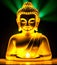 Sitting statue of smiling buddha with lighted candles. Golden buddha glowing holy colorful light.