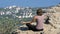 Sitting woman in lotus position practicing yoga moves. Cliff top with the cross.