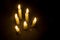 Six burning candles on black, view from above, copy space
