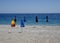 Six closed beach umbrellas on an empty beach