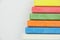 Six colored children crayons on white background, right side, blue red green yellow orange white, top view, copy space