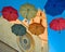 Six colorful umbrellas against gothic cathedral and blue sky.