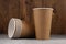 Six eco-friendly cardboard cups lie on a concrete surface on a wooden background. Mock-up. Close-up.