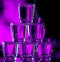 Six glasses stacked by a tower on a multi-colored background