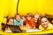 Six kids lay in a yellow tent