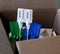 Six new plastic cargo seals in different colors are peeking out of an open shipping carton