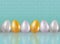 A six painted or dyed in metallic gold, silve, platinum colors chicken eggs on blue brick wall background with reflaction. Healthy