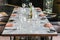 Six people dinner table with plates, knives, forks, wine glasses, glasses and napkins on marble table top