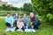 Six people family portrait at weekend picnic, senior grandparents, adult single father, preteen age girl and boy, toddler girl