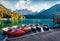 Six pleasure boats on Fusine lake. Splendid morning scene of Julian Alps with Mangart peak on background, Province of Udine, Italy