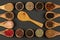 Six small wooden bowls and eight cooking spoons made of olive wood filled with various spices