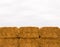 Six stacked yellow hay bales on overcast sky