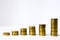Six stacks of coin in ascending order on white gray background. Photo illustration of success in business and commerce, growth of