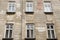 Six vintage white windows on the facade of the ragged old house