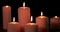 Six white Christmas candles burning on dark