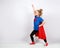 Six year blonde girl dressed like superhero having fun at home. White wall on background