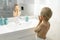 Six-year-old boy applies aftershave like dad in the morning in the bath, hygiene in the morning