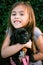 Six year old girl holding boxer-pitbull black puppy