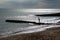 A six year old unrecognisable boy walking along a jetty in the sea