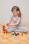 Six years old little girl playing with building blocks toys. Construction activity