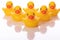 Six yellow rubber ducks lined up in wedge on white background. Team army concept