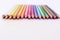 Sixteen pencils white yellow orange pink red blue green brown black on a white surface