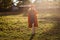 Sixteen-year-old smiling teen girl in a red beret and orange coat in direct sunlight outdoors