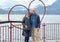 Sixty-five year-old Korean tourist and her seventy-six year old Caucasian husband posing in a a heart beside Lake Como.