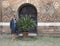 Sixty-five year old Korean tourist beside a Sago palm in the courtyard of Pilate in the Basilica of Saint Stephen.