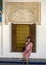 Sixty-four year-old female Korean tourist sitting on the mosaic tile sill of a window in the Bahia Palace in Marrakesh, Morocco.