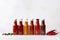 Sizzling Composition: Minimalist photo featuring up-close fiery sauce bottles on a clean white wooden backdrop, adorned
