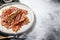 Sizzling hot bacon pieces. Organic meat. Gray background. Top view. Copy space