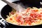 Sizzling Skillet Delight: Pasta and Diced Ham Dance on a White Canvas