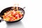 Sizzling Skillet Delight: Pasta Tossed with Diced Ham in a Dynamic White Background